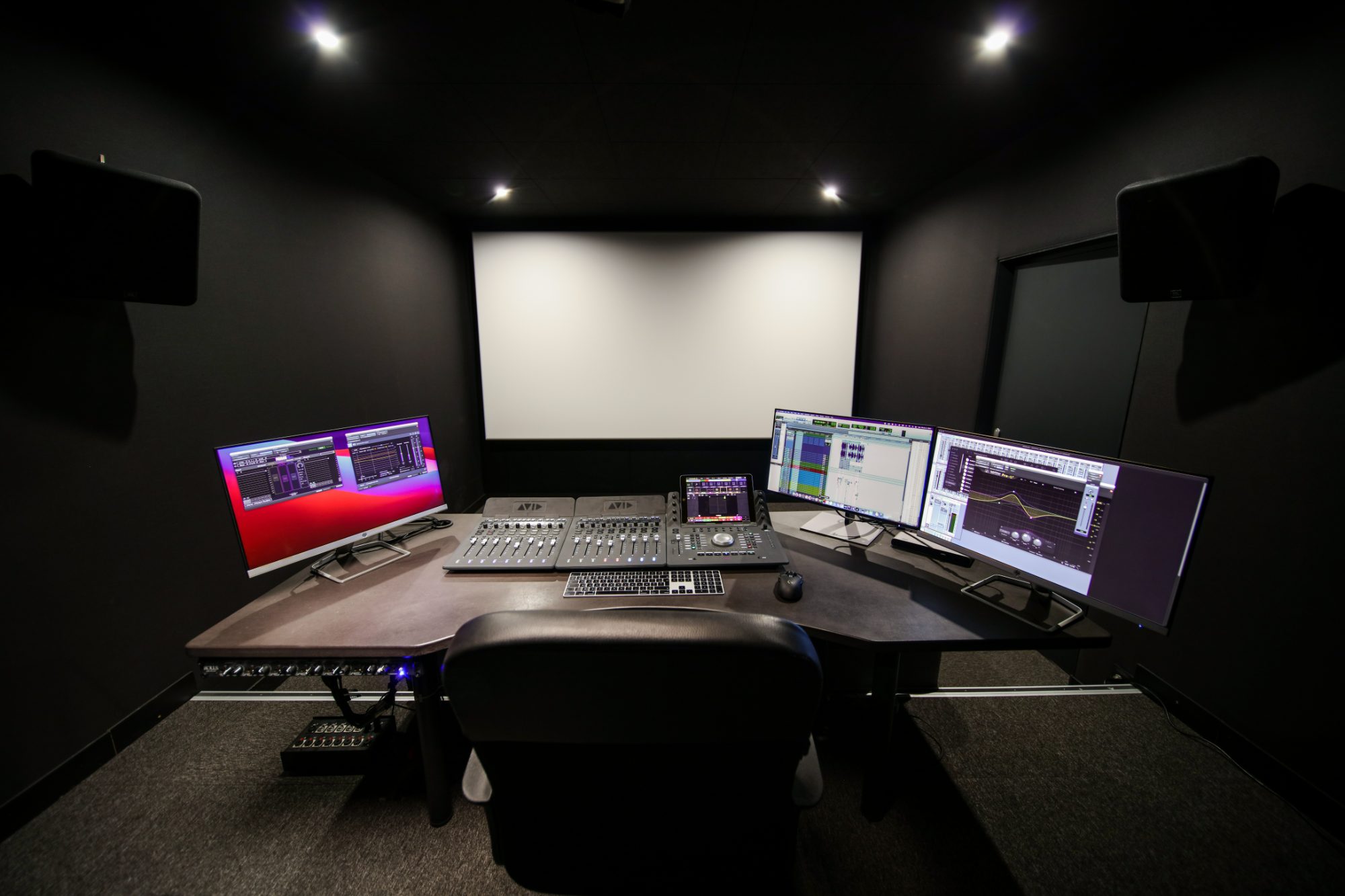 Auditorium de mixage : console Avid, écran de projection et enceintes
